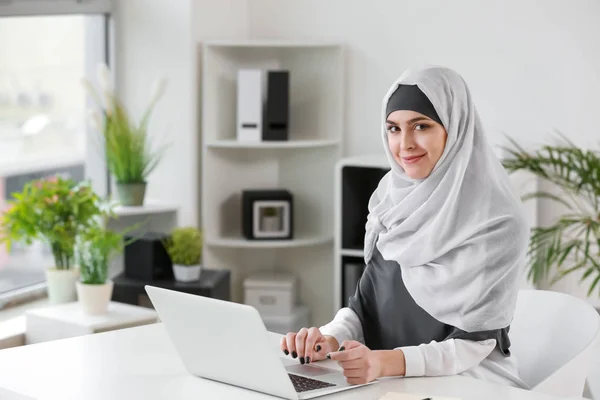 Muslimsk kvinna som arbetar på laptop på kontoret — Stockfoto