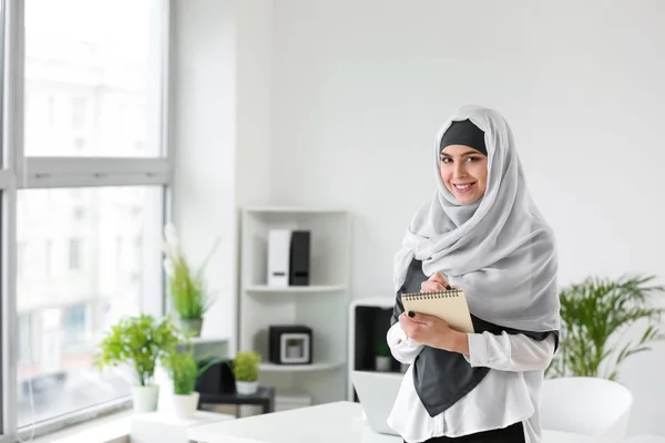 Mulher muçulmana com caderno no cargo — Fotografia de Stock