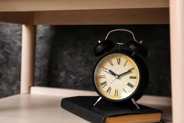 Livre et horloge sur étagère dans la chambre — Photo