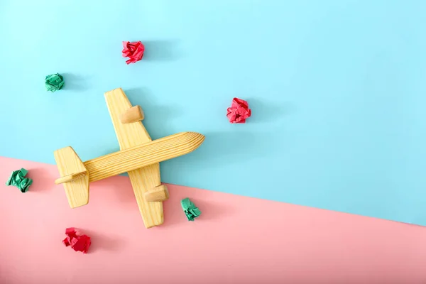 色の背景にしわの紙と木製の飛行機。旅行コンセプト — ストック写真