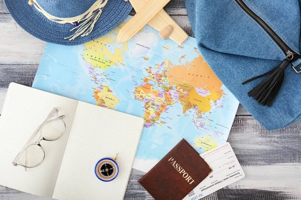 Carte du monde avec passeport, billets, carnet et accessoires féminins sur table en bois. Concept de voyage — Photo