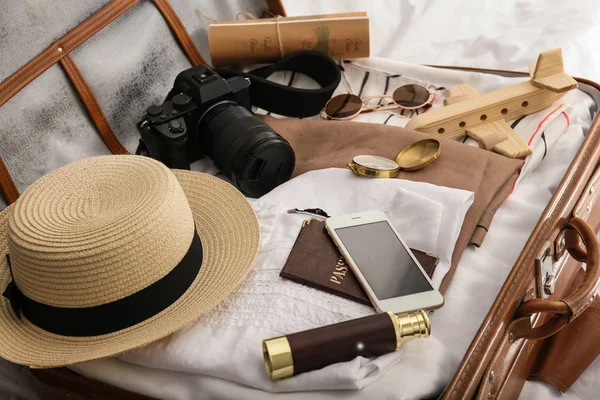 Valigia con abiti femminili e accessori da viaggio sul letto — Foto Stock