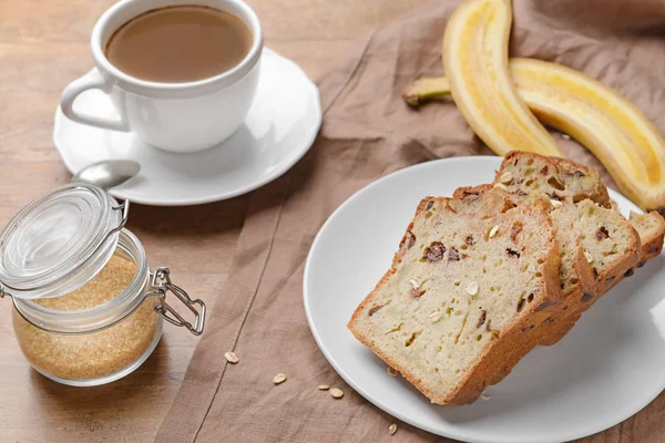 Tasty banana bread with cup of coffee on wooden table — Stock Photo, Image