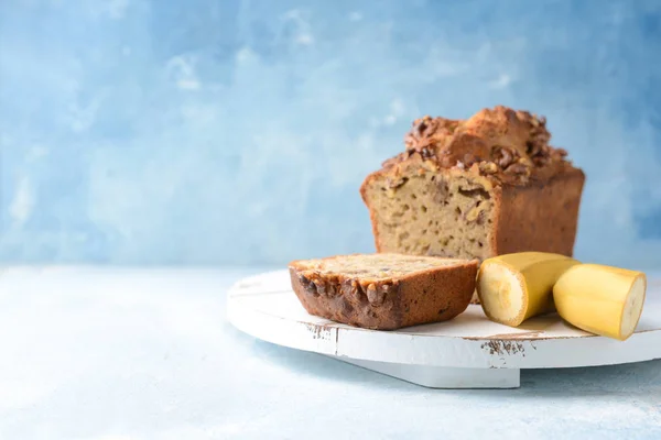 Board with tasty banana bread on color background — Stock Photo, Image