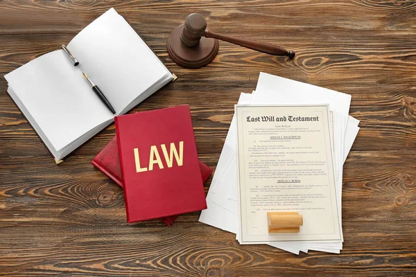 Документ с молотком судьи, книга законов и канцелярские принадлежности на деревянном столе — стоковое фото