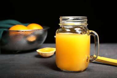 Karanlık masada taze sıkılmış portakal suyu Mason kavanoz