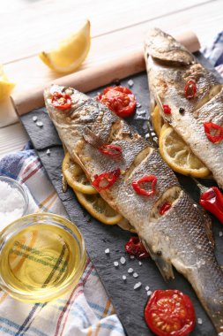 Beyaz ahşap masada lezzetli pişmiş balık