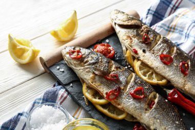 Beyaz ahşap masada lezzetli pişmiş balık