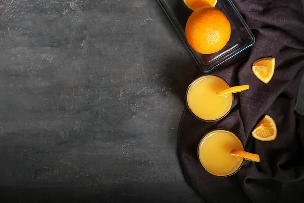 Gläser mit frisch gepresstem Orangensaft auf dunklem Tisch — Stockfoto