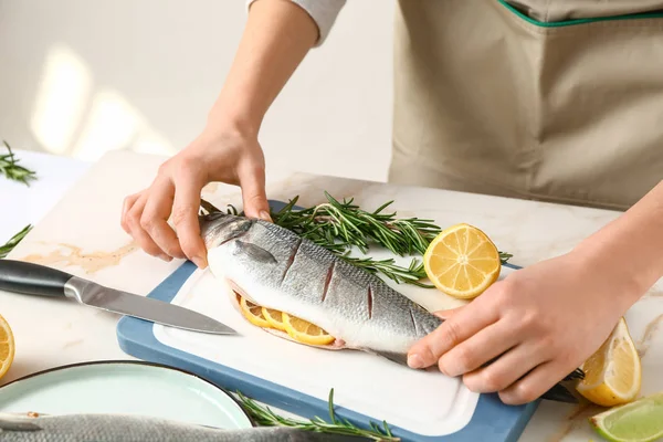 Žena připravuje chutné čerstvé ryby — Stock fotografie