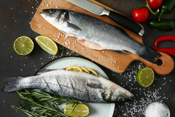 Příprava chutných čerstvých ryb na tmavém stole — Stock fotografie