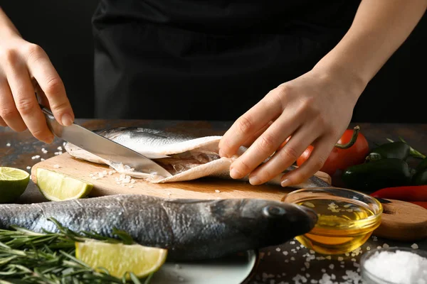 Žena připravuje chutné čerstvé ryby — Stock fotografie