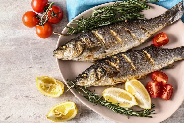 Placa con sabroso pescado cocido en mesa ligera —  Fotos de Stock