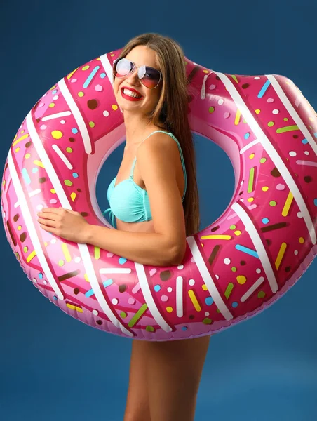 Hermosa mujer joven con anillo inflable sobre fondo de color — Foto de Stock