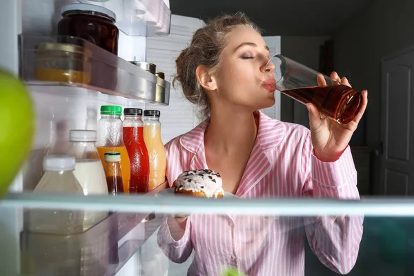 Piękna młoda kobieta picie soku w pobliżu lodówki, widok od wewnątrz — Zdjęcie stockowe