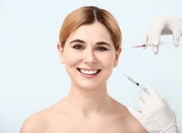 Beautiful woman and hands holding syringes for anti-aging injections on white background — Stock Photo, Image