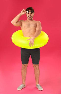 Renkli arka planda şişme yüzük ile yakışıklı adam