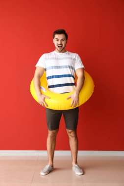 Renkli duvara yakın şişme yüzük ile yakışıklı adam