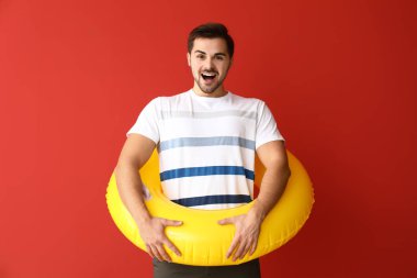 Renkli arka planda şişme yüzük ile yakışıklı adam