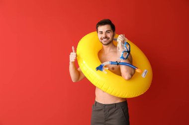 Renkli arka planda şişme yüzük ve şnorkelli yüzme maskesi ile yakışıklı adam