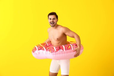 Renkli arka planda şişme yüzük ile yakışıklı adam