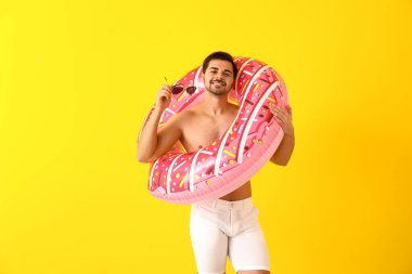 Renkli arka planda şişme yüzük ile yakışıklı adam