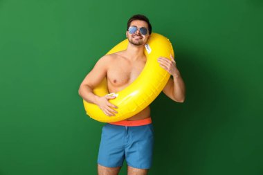 Renkli arka planda şişme yüzük ile yakışıklı adam