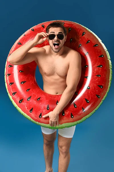 Excited man with inflatable ring on color background — Stock Photo, Image