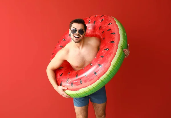 Handsome man with inflatable ring on color background — Stock Photo, Image