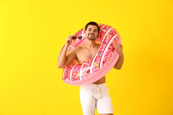 Bello uomo con anello gonfiabile su sfondo a colori — Foto Stock