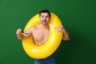 Renkli arka planda şişme yüzük ile yakışıklı adam