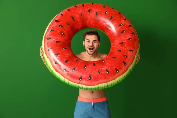 Excited man with inflatable ring on color background — Stock Photo, Image