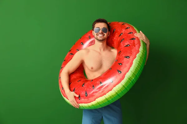Renkli arka planda şişme yüzük ile yakışıklı adam — Stok fotoğraf