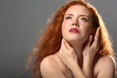 Gri arka planda güzel bir genç kadının portresi