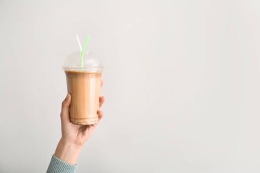Hafif arka planda lezzetli frappe kahve kadın el tutan fincan