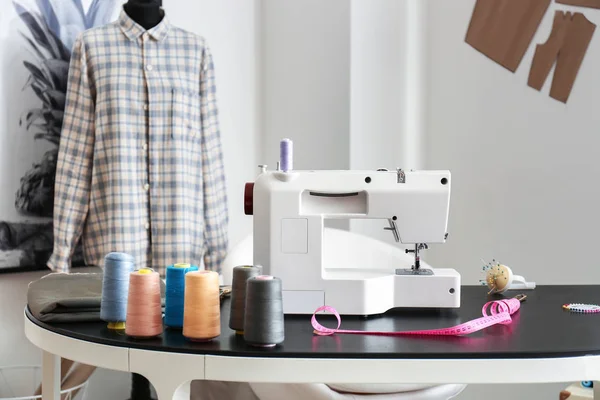 Máquina de coser con accesorios en el lugar de trabajo del sastre en el taller —  Fotos de Stock