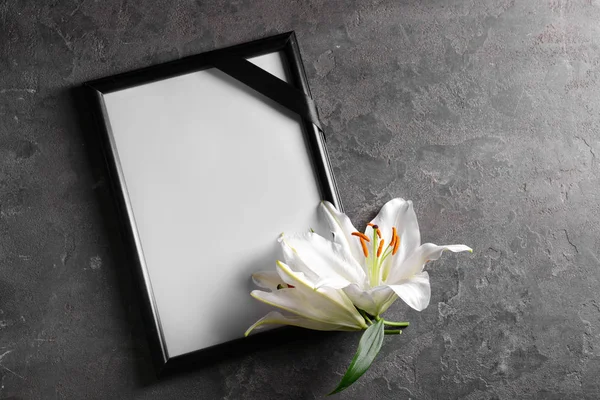 Blank funeral frame and flowers on grey background