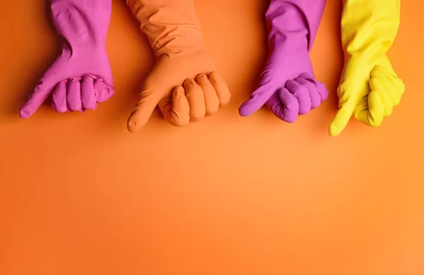 Hands in rubber gloves showing thumb-up on color background