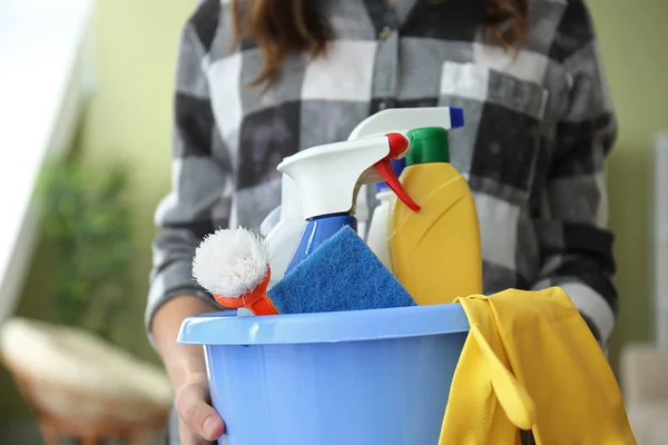 Vrouw met set van schoonmaakbenodigdheden in de kamer — Stockfoto