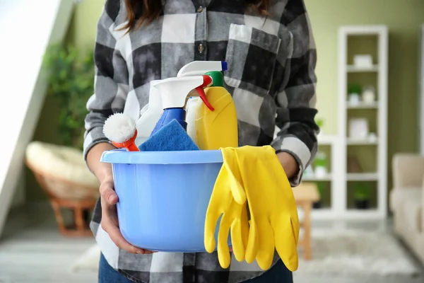 Woman with set of cleaning supplies in room — Stock Photo, Image