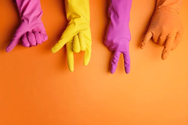 Hands in rubber gloves showing different gestures on color background — Stock Photo, Image