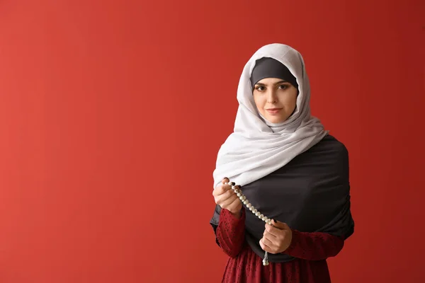 Muslim woman with tasbih on color background — Stock Photo, Image