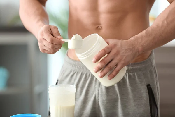 Sporty man making protein shake at home — Stock Photo, Image