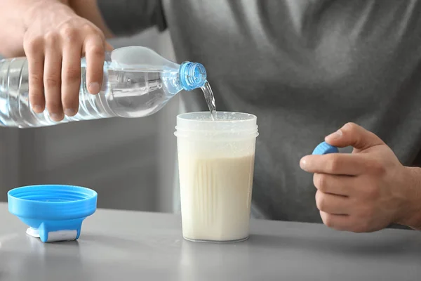 Sporty man making protein shake at home — Stock Photo, Image