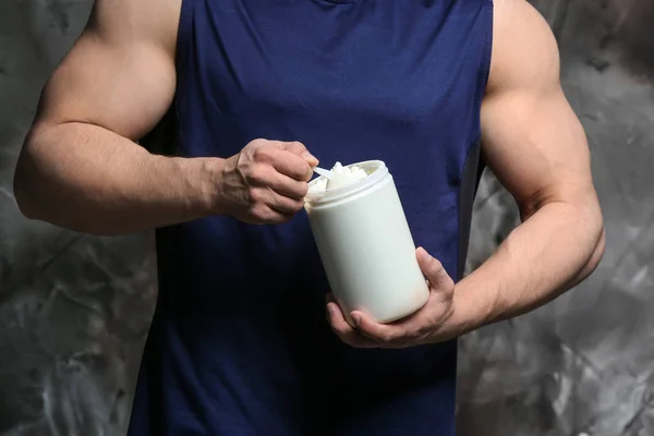 Sportig man med protein på grunge bakgrund — Stockfoto