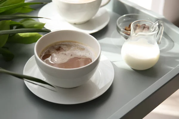 Xícara de café frappe saboroso e leite na bandeja — Fotografia de Stock