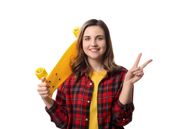 Beautiful young woman with skateboard showing victory gesture on white background — Stock Photo, Image