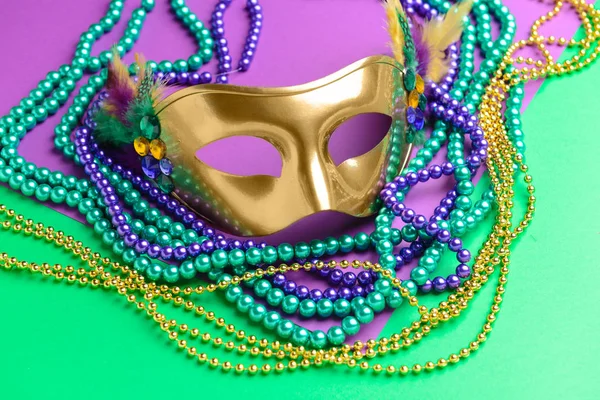 Праздничная маска с бусами на цветном фоне — стоковое фото