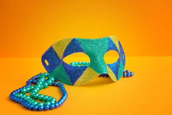 Festive mask with beads on color background — Stock Photo, Image