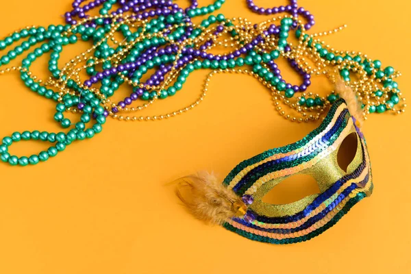 Maschera festiva con perline su sfondo a colori — Foto Stock